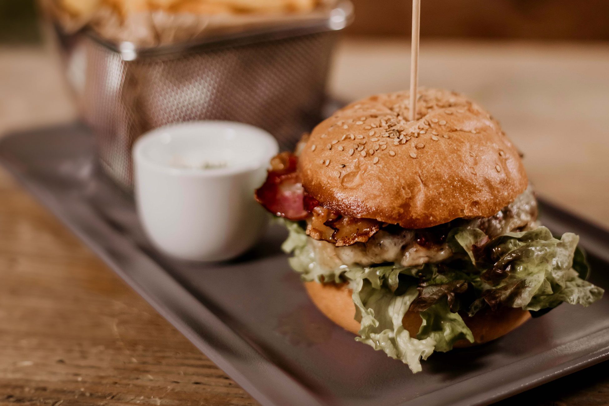 Land.Luft Burger auf einem Teller mit Ofenkartoffeln und Dip