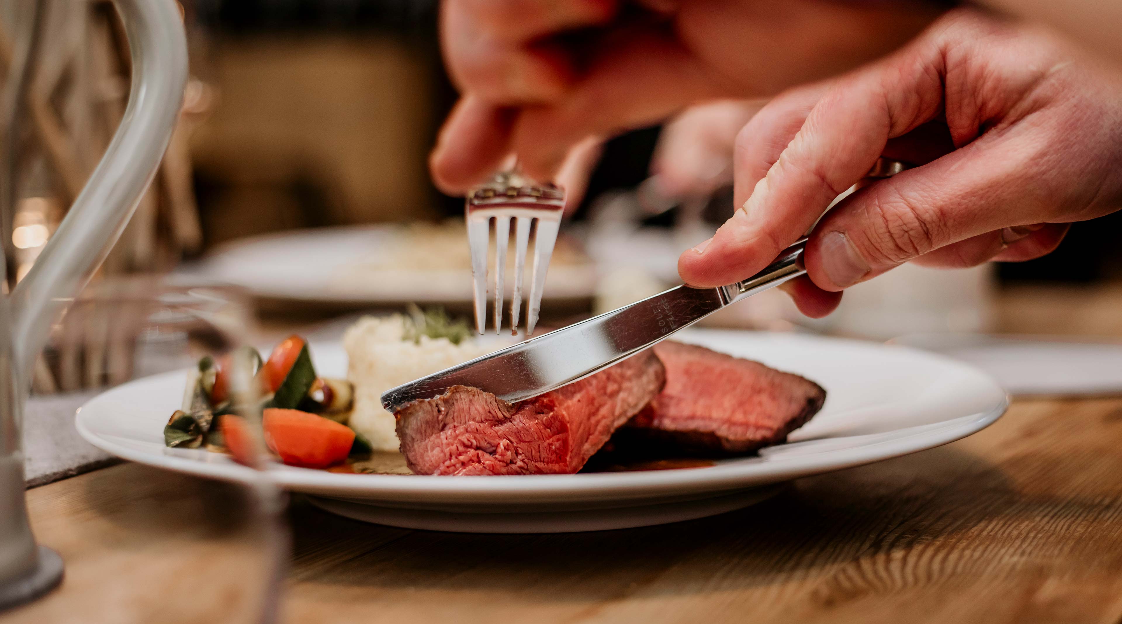 Bio Restaurant Titelbild zeigt ein Medium Steak das gerade angeschnitten wird